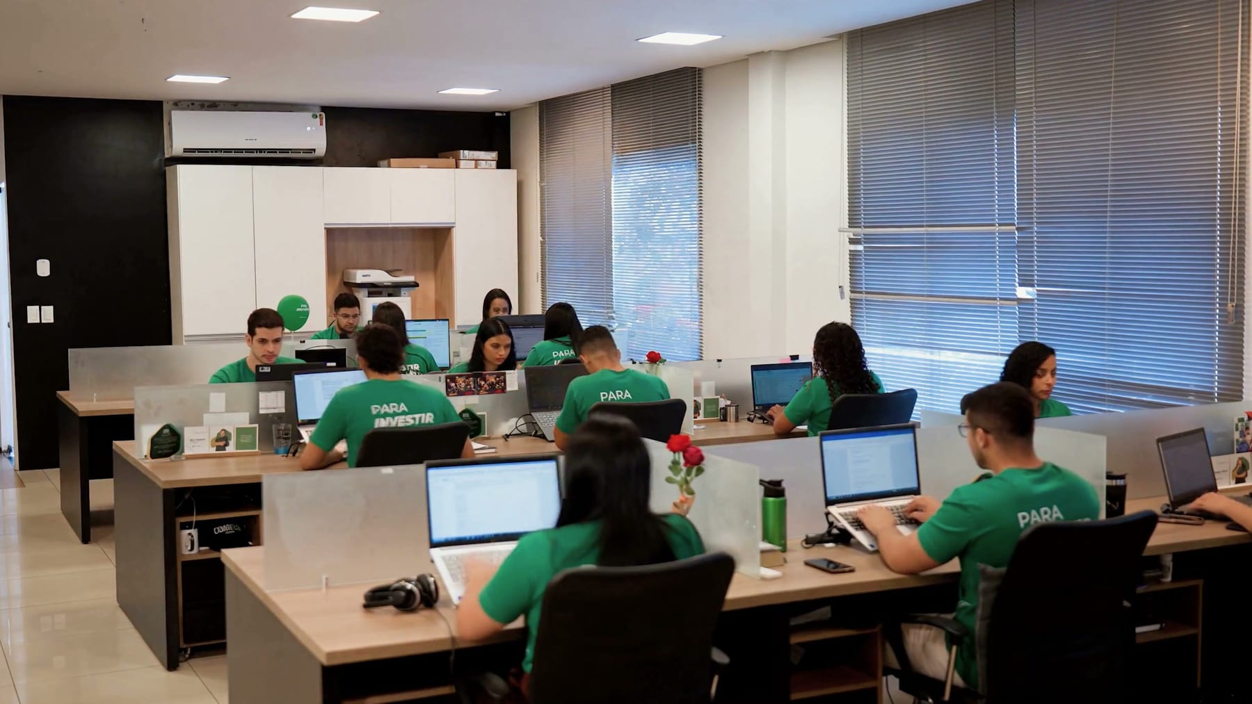 Equipe da Eco Urbanismo, de camisa verde, trabalhando no escritório da empresa